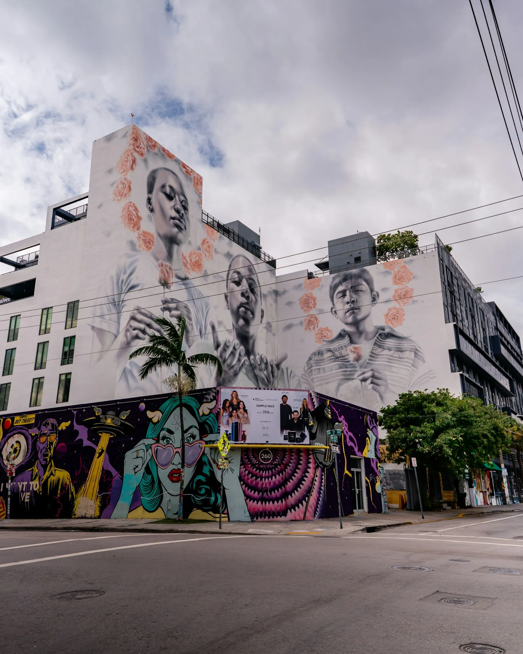 A building facade covered by a large mural of three faces
