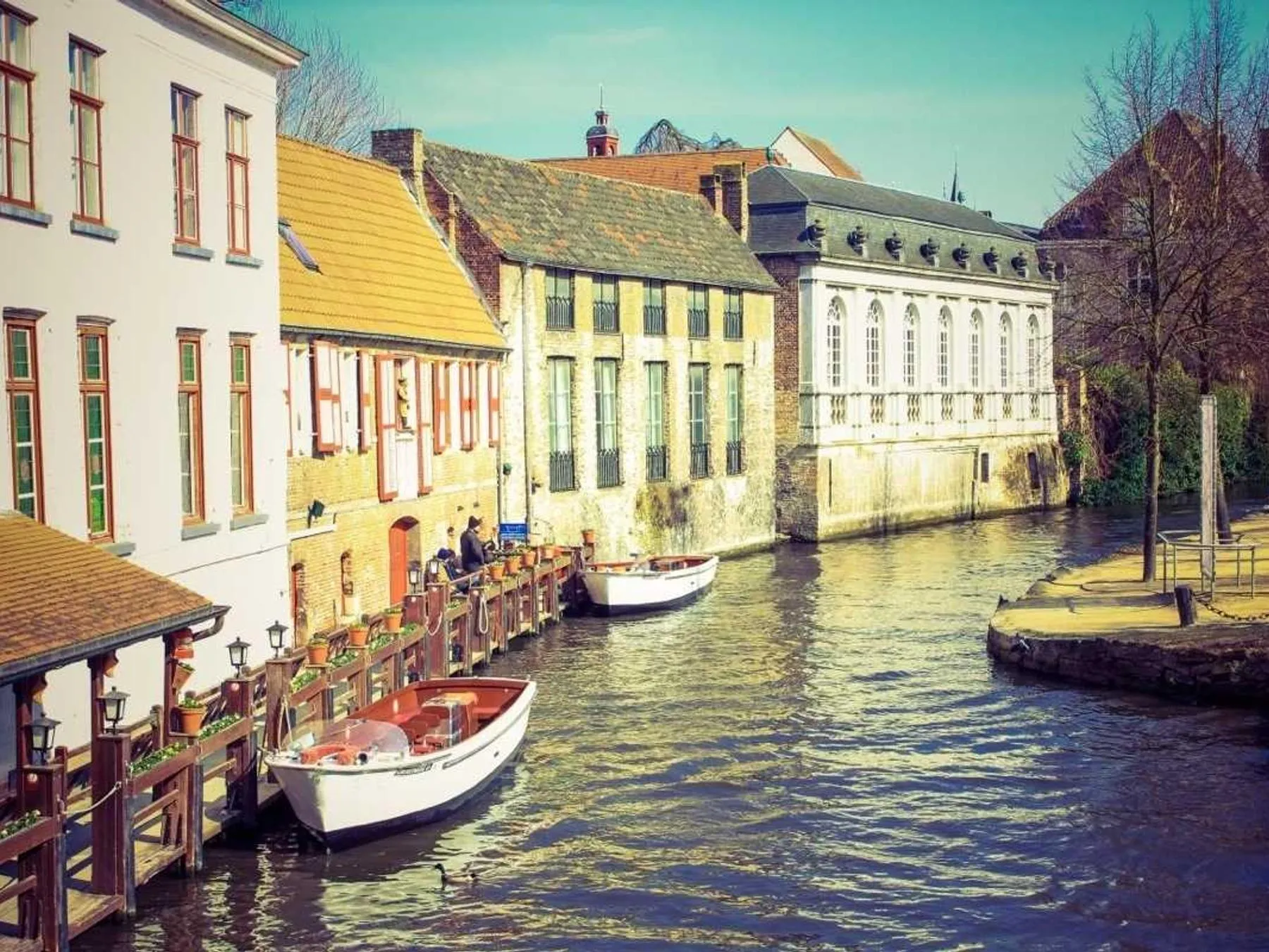 Historic gabled canal houses with small boats moored along the water