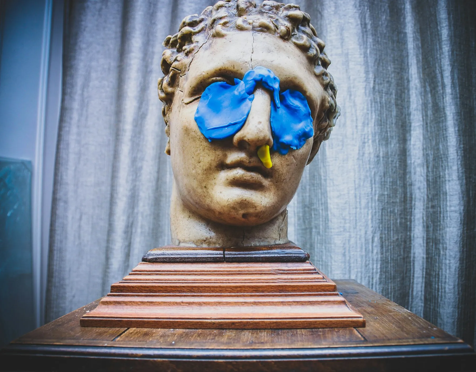 A strange sculptural head against a pale wall
